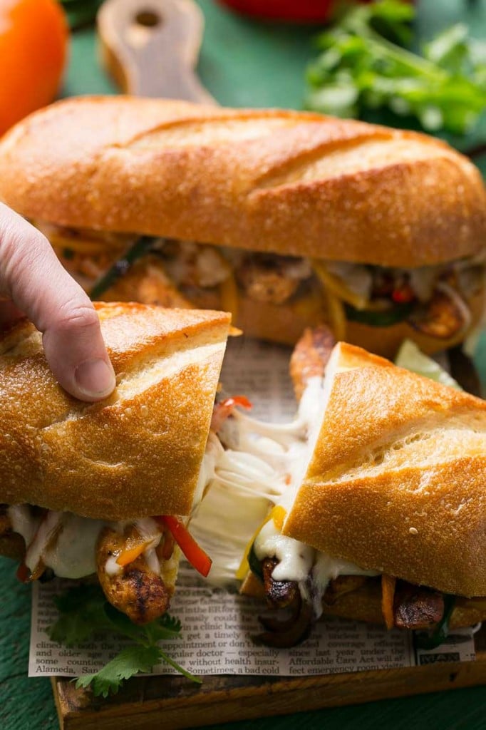 These fajita chicken cheesesteak sandwiches are full of spiced chicken, peppers and lots of cheese, all on a toasted roll.