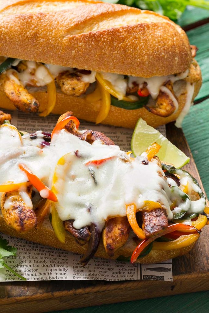 These fajita chicken cheesesteak sandwiches are full of spiced chicken, peppers and lots of cheese, all on a toasted roll.