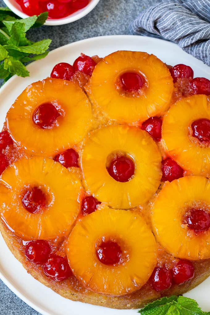 Pineapple upside down cake on a serving platter, garnished with fresh mint.