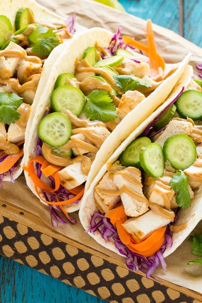 These thai chicken tacos are a quick and easy dinner. Coconut marinated chicken is stuffed into warm tortillas with fresh vegetables and a generous amount of homemade peanut sauce.