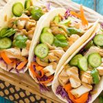 These thai chicken tacos are a quick and easy dinner. Coconut marinated chicken is stuffed into warm tortillas with fresh vegetables and a generous amount of homemade peanut sauce.