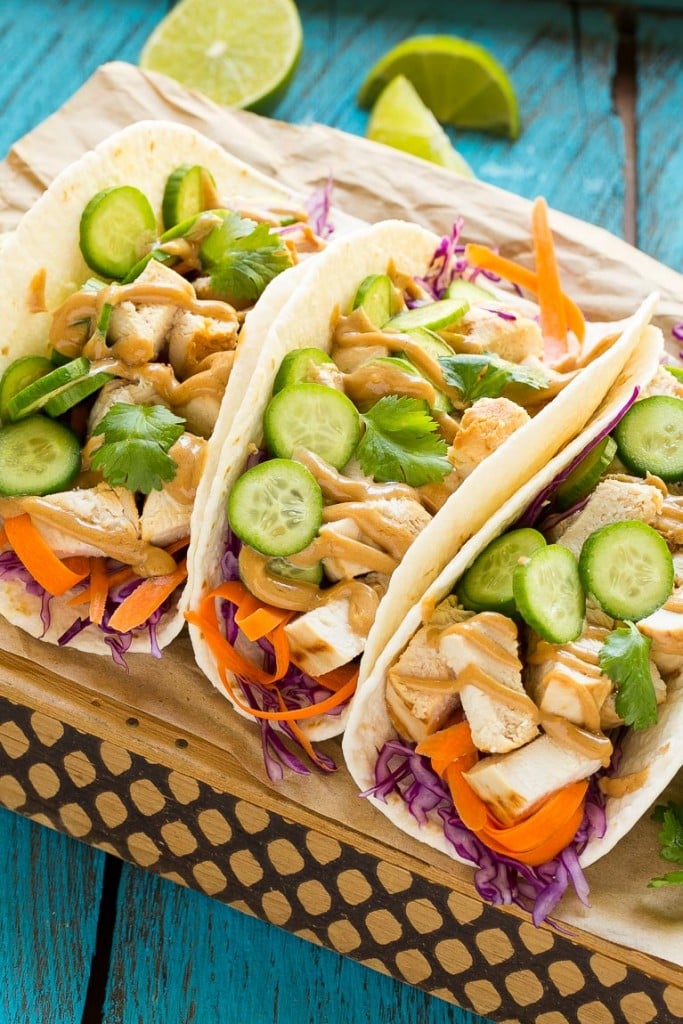 These thai chicken tacos are a quick and easy dinner. Coconut marinated chicken is stuffed into warm tortillas with fresh vegetables and a generous amount of homemade peanut sauce.