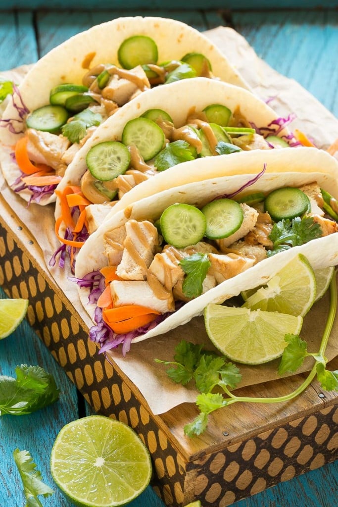 These thai chicken tacos are a quick and easy dinner. Coconut marinated chicken is stuffed into warm tortillas with fresh vegetables and a generous amount of homemade peanut sauce.