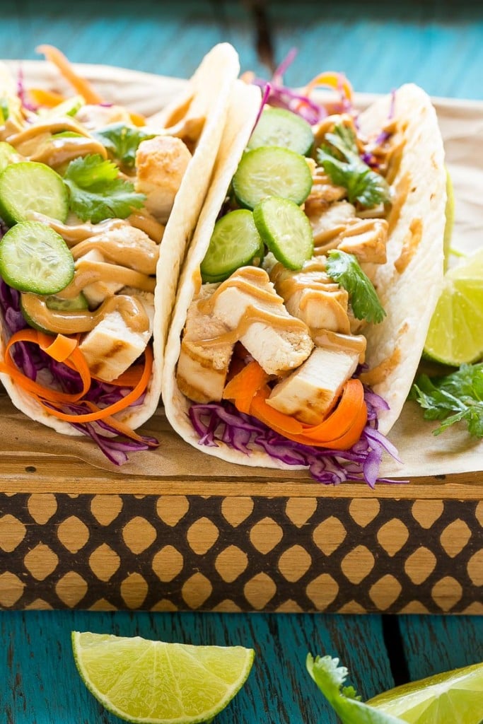 These thai chicken tacos are a quick and easy dinner. Coconut marinated chicken is stuffed into warm tortillas with fresh vegetables and a generous amount of homemade peanut sauce.