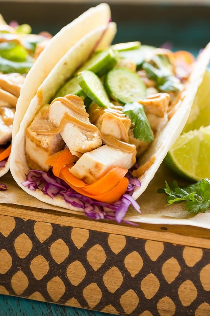 These thai chicken tacos are a quick and easy dinner. Coconut marinated chicken is stuffed into warm tortillas with fresh vegetables and a generous amount of homemade peanut sauce.