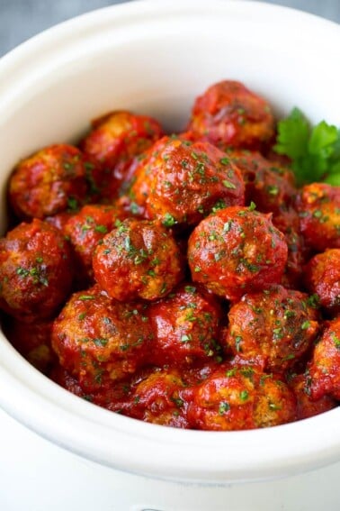 Turkey meatballs in tomato sauce inside a slow cooker.