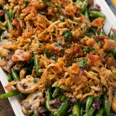 These green beans are cooked in a ranch butter sauce and topped with crispy onions and bacon. SO much better than green bean casserole!