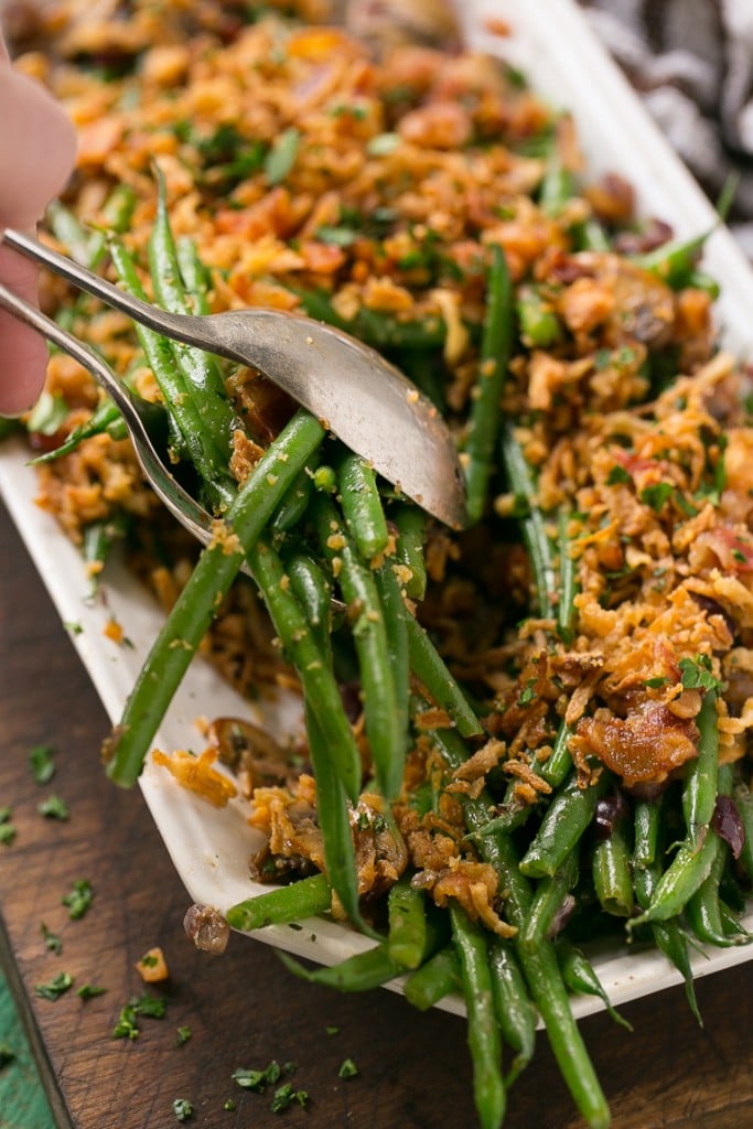 These green beans are cooked in a ranch butter sauce and topped with crispy onions and bacon. SO much better than green bean casserole!