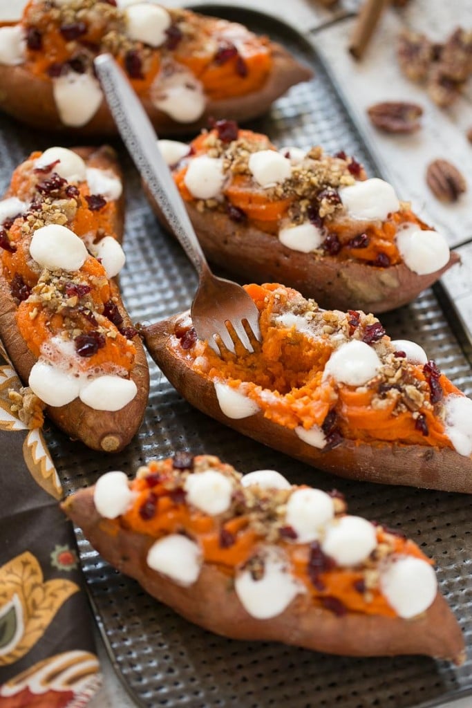 These loaded twice baked sweet potatoes are piled high with pecan brown sugar streusel, marshmallows and dried cranberries. You can prepare them in advance and then pop them in the oven right before your holiday meal!