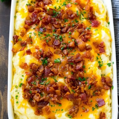 Loaded mashed potato casserole topped with melted cheese, bacon and herbs.