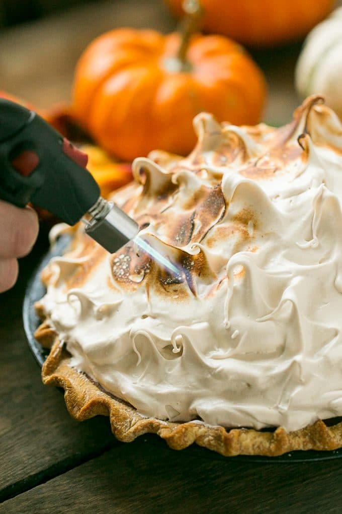 A torch browning meringue on a pie.