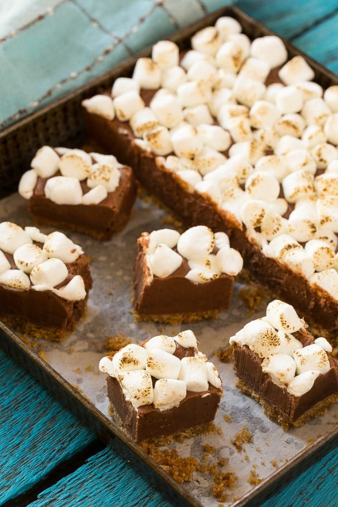 Chocolate fudge in a pan with graham cracker on the bottom and marshmallow on top.