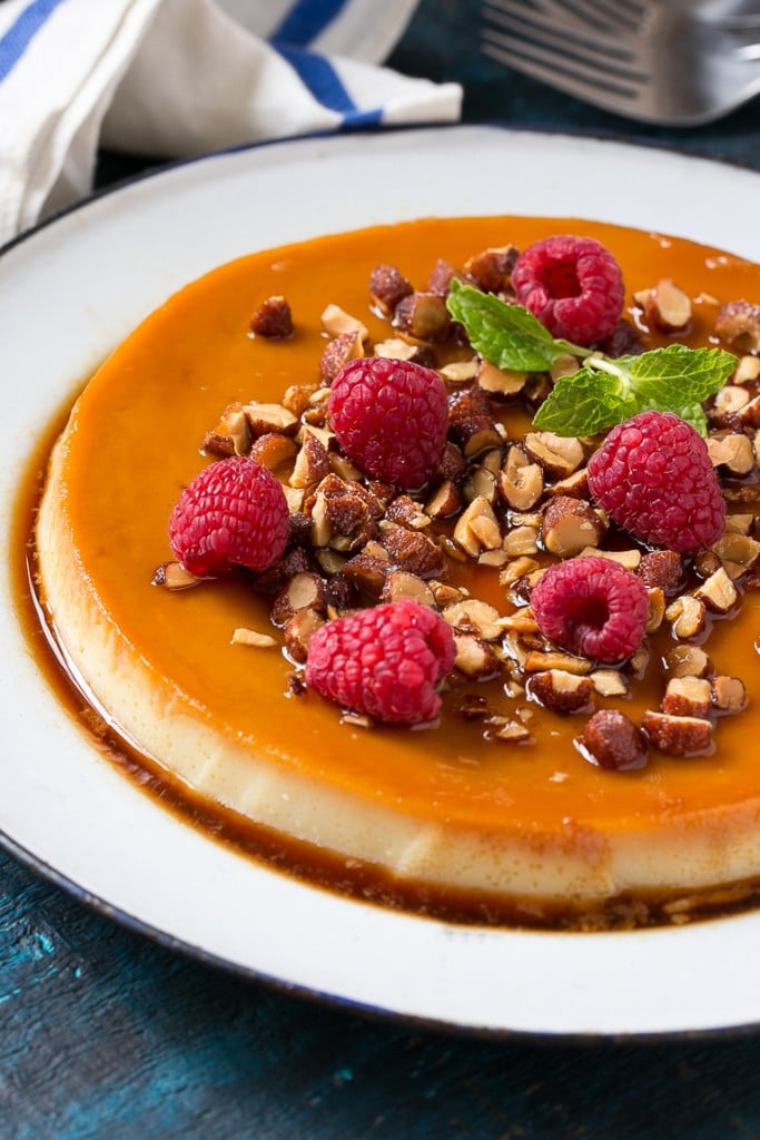 This rich and creamy flan is flavored with vanilla and almonds and is finished off with chopped honey roasted almonds and raspberries.