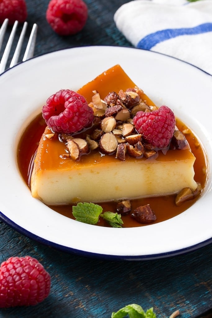 This rich and creamy flan is flavored with vanilla and almonds and is finished off with chopped honey roasted almonds and raspberries.