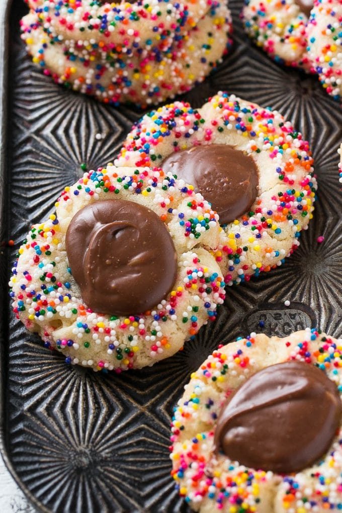 Cookies topped with rainbow sprinkles and a center of fudge.
