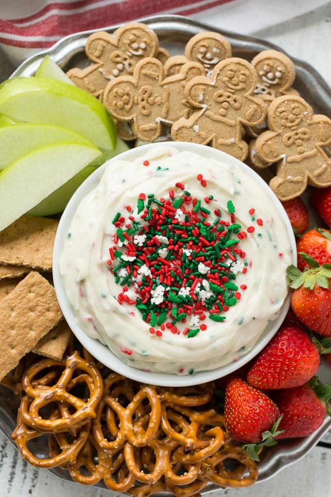 This Christmas cookie dough dip has a fluffy and creamy base that's swirled with plenty of holiday sprinkles and served with fruit and cookies for dipping. It only takes 5 minutes to make! #HolidayWithChobani Ad