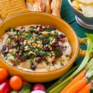 This mediterranean layered dip starts with a base of whipped feta cheese and is topped with artichokes, olives, sun dried tomatoes and pine nuts. Ready in about 10 minutes, it's the perfect party appetizer!