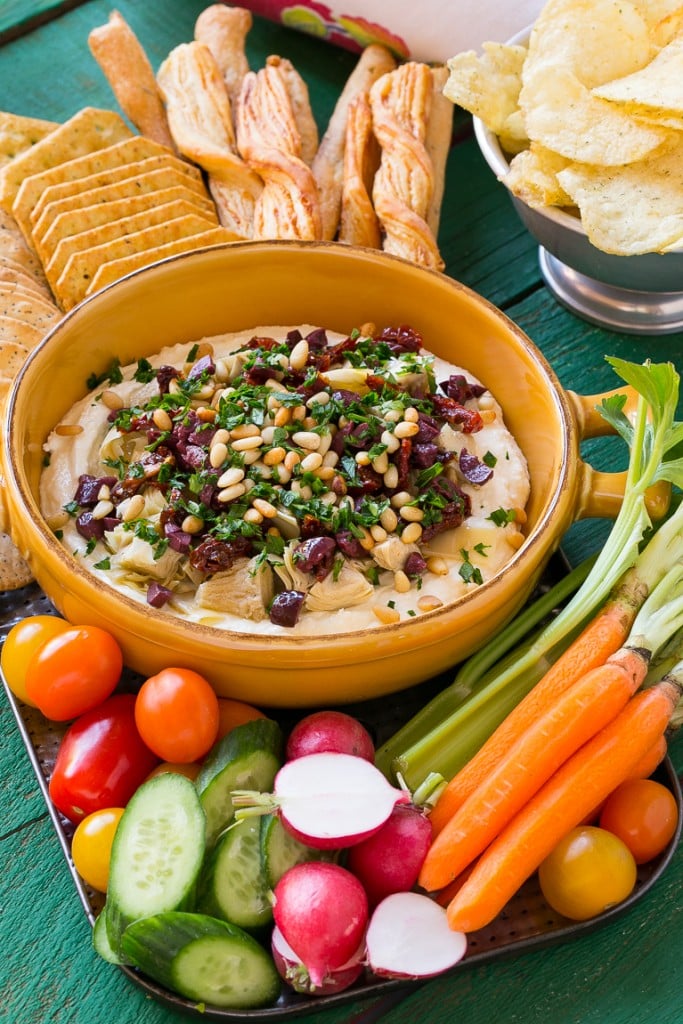 This mediterranean layered dip starts with a base of whipped feta cheese and is topped with artichokes, olives, sun dried tomatoes and pine nuts. Ready in about 10 minutes, it's the perfect party appetizer!