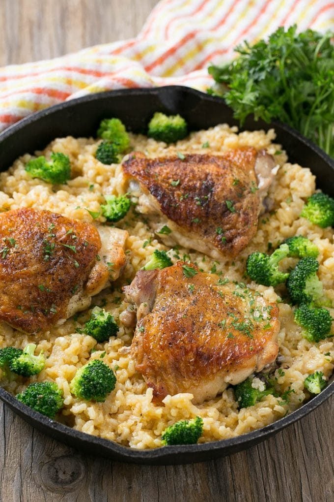 Chicken broccoli and rice casserole in a skillet garnished with parsley.