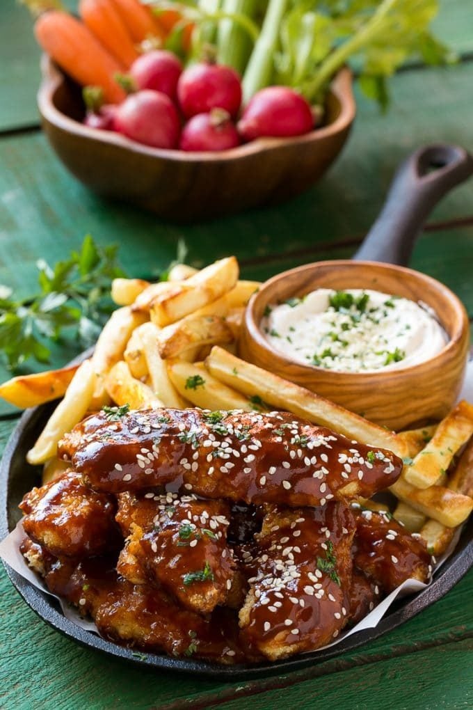 Sesame chicken fingers and fries with dipping sauce.