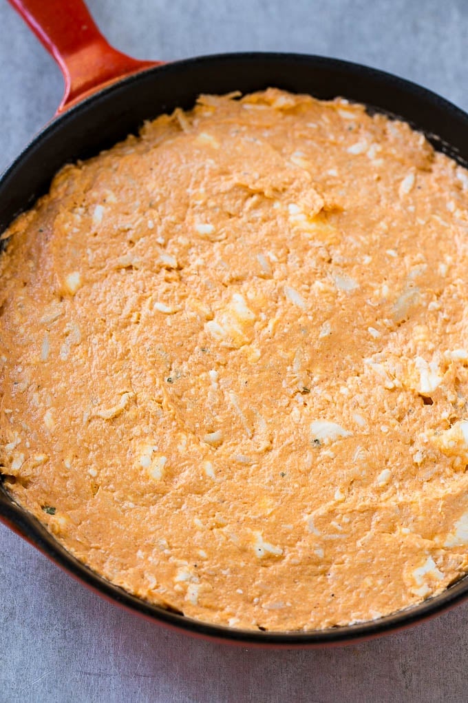 The base layer of buffalo chicken dip made with cream cheese, chicken, ranch and hot sauce.