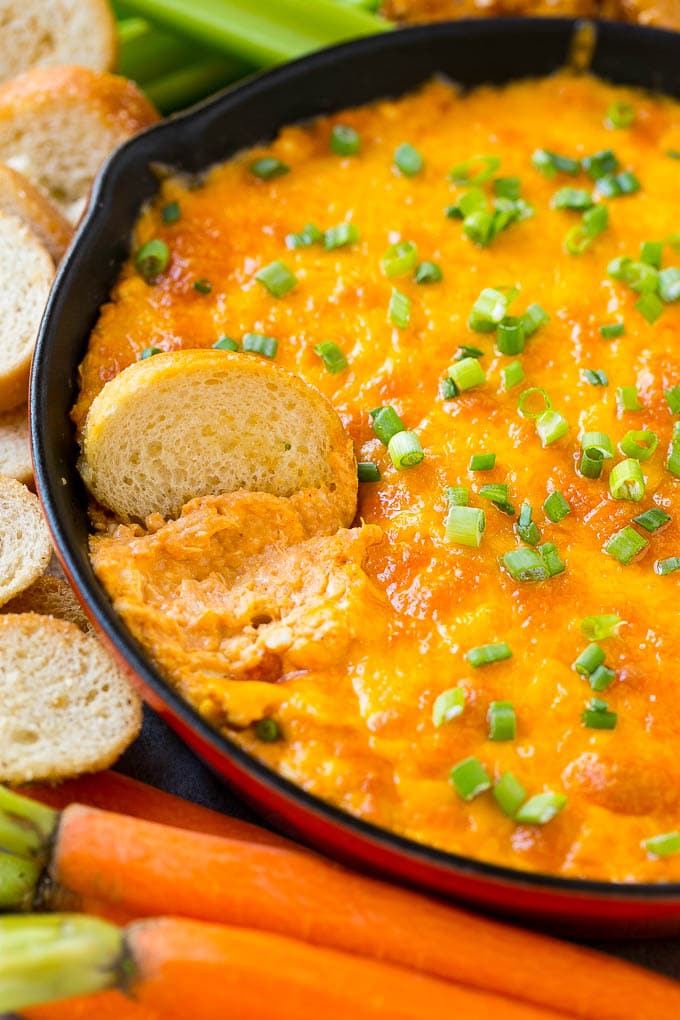 Buffalo ranch chicken dip with a baguette slice in it.