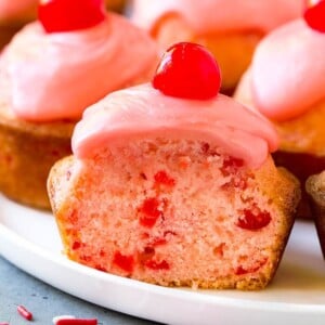 Cherry muffins studded with maraschino cherries and topped with pink glaze.