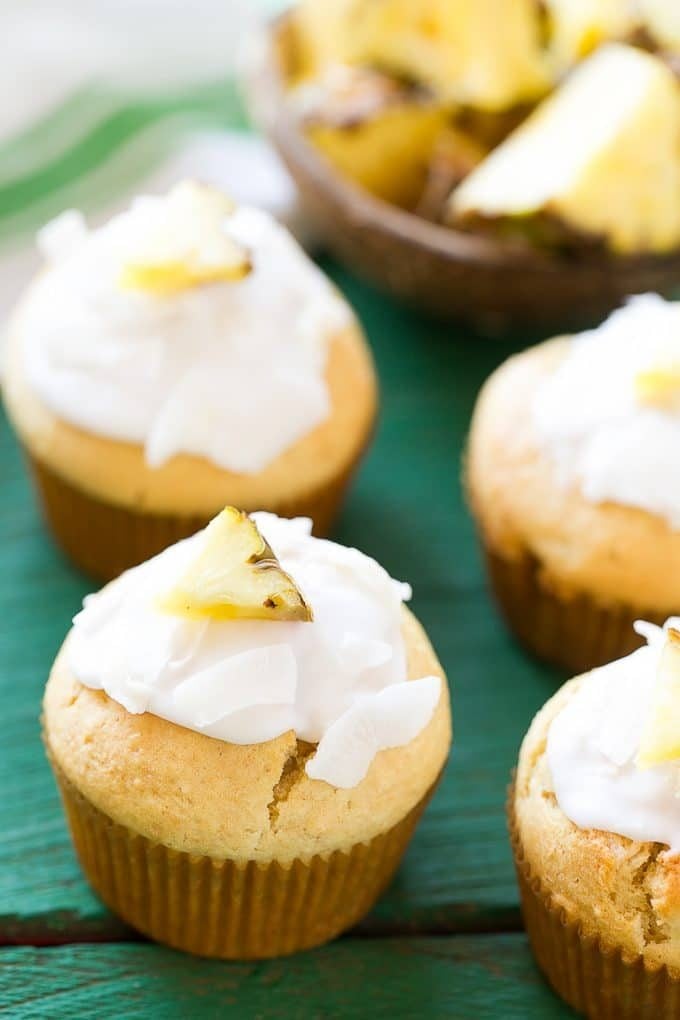 Coconut muffins topped with shredded coconut and pineapple.