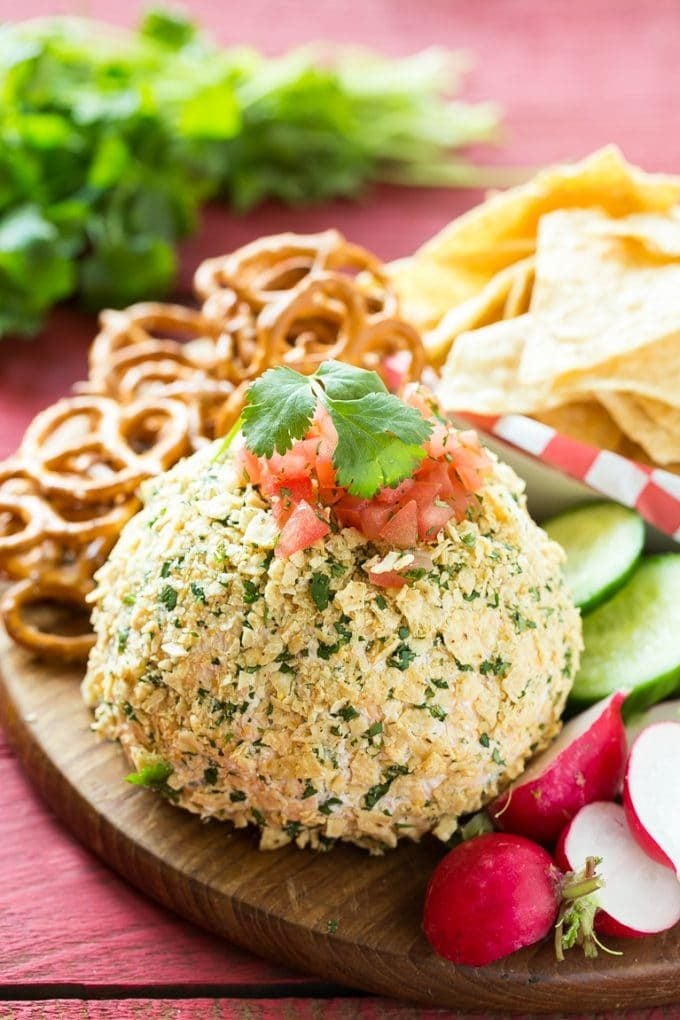 A cheddar cheese ball served with vegetables, chips and pretzels.