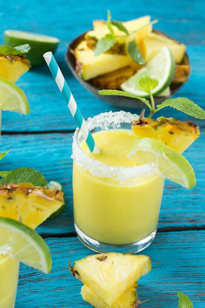Pineapple Coconut Smoothie Recipe |Tropical Smoothie | Pineapple Smoothie #smoothie #pineapple #coconut #healthy #cleaneating #dinneratthezoo A tropical smoothie with a paper straw in it.