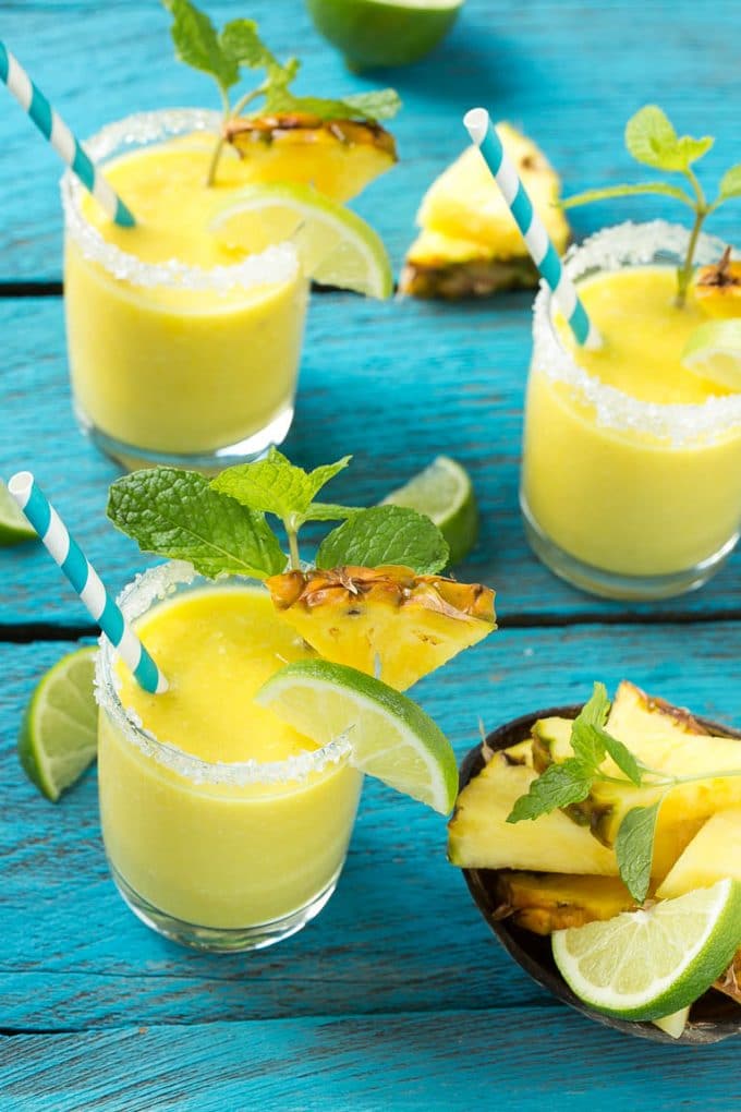 Pineapple Coconut Smoothie Recipe |Tropical Smoothie | Pineapple Smoothie #smoothie #pineapple #coconut #healthy #cleaneating #dinneratthezoo Pineapple coconut smoothies in glasses with sugared rims.