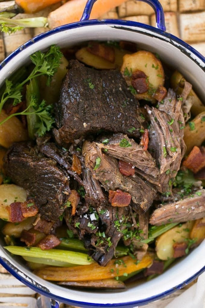 A pot of beef roast, carrots, celery and potatoes.