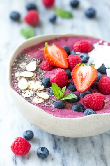 This acai bowl recipe is a smoothie made with fruit, acai berry puree and yogurt that's served in a bowl and finished with a fun and colorful variety of toppings.