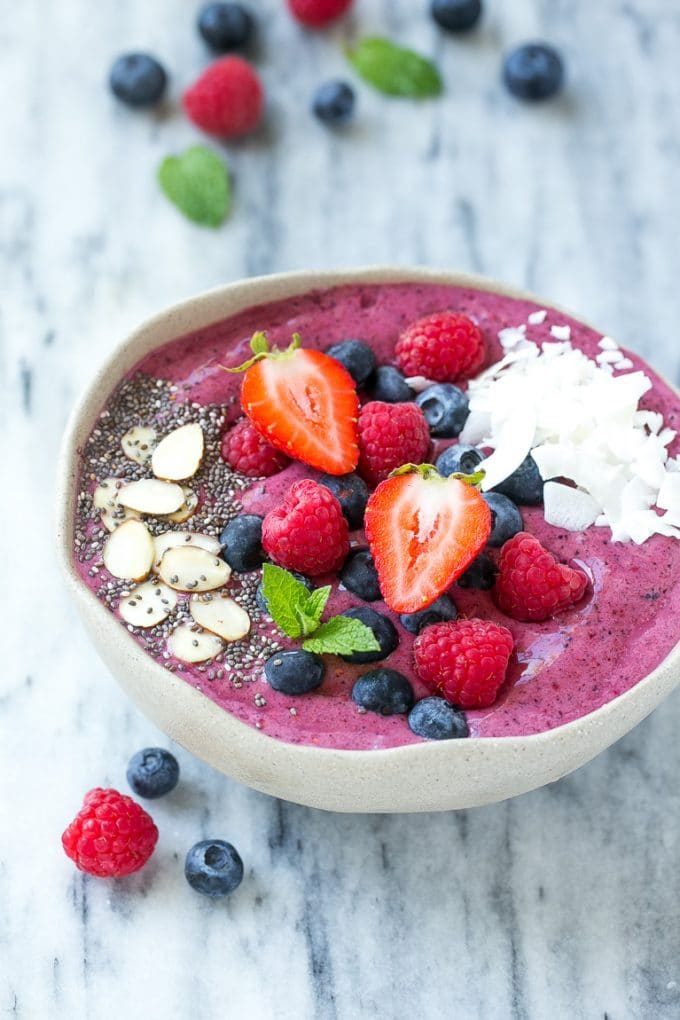 An acai bowl topped with berries, nuts and chia seeds.