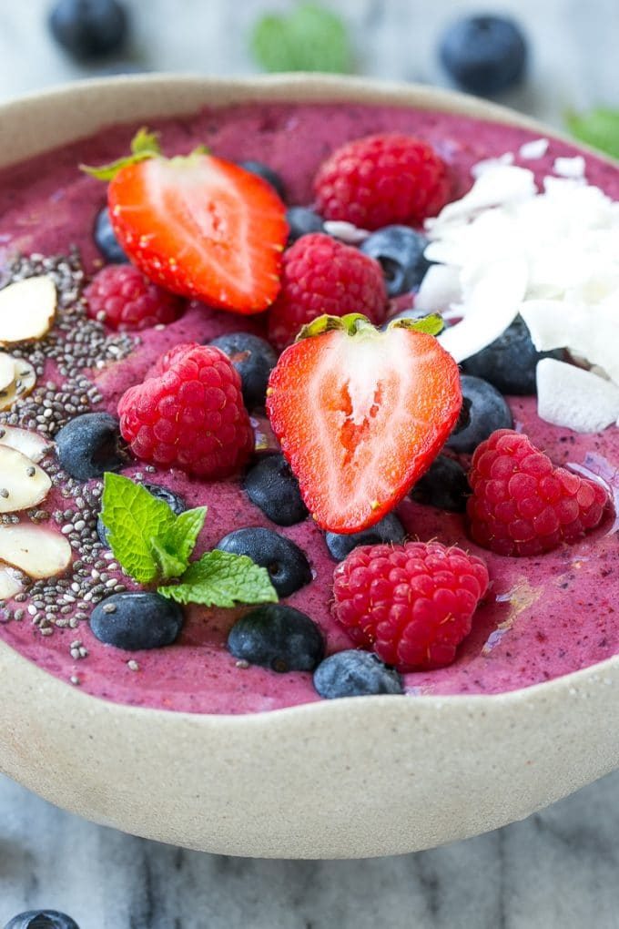 An acai bowl made with frozen berries, then topped with fresh fruit, coconut and seeds.