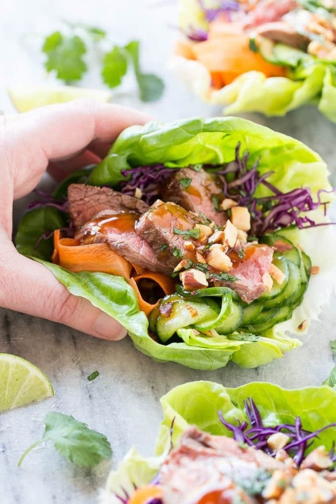 A hand reaching for a steak lettuce cup.