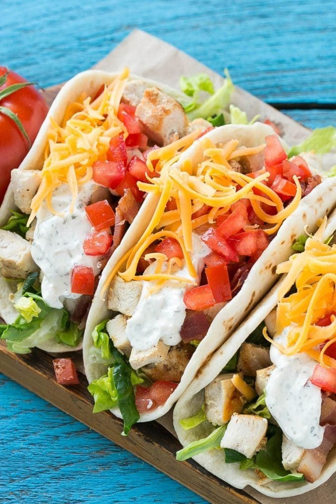 Chicken tacos filled with lettuce, tomatoes, ranch and bacon.