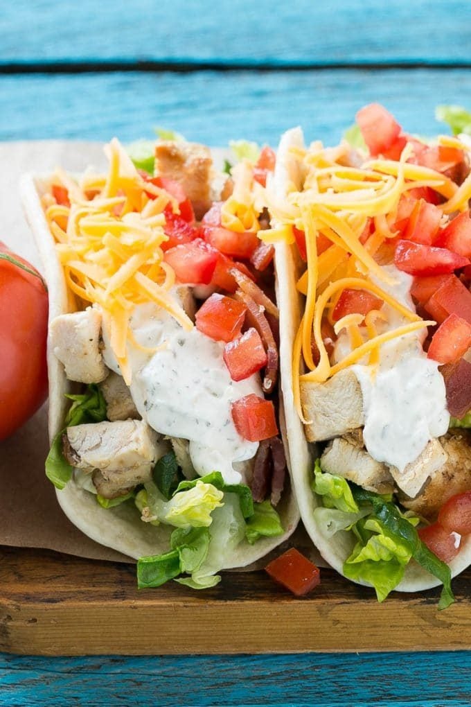 Chicken ranch tacos with tomatoes, bacon, lettuce and cheese.