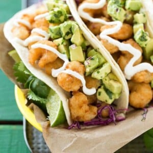 This recipe for fried shrimp tacos is a pile of crispy shrimp that's layered with cilantro lime cabbage slaw and avocado relish then stuffed inside warm flour tortillas. It's a quick and easy meal that tastes like it came from a restaurant! #ShrimpItUp ad