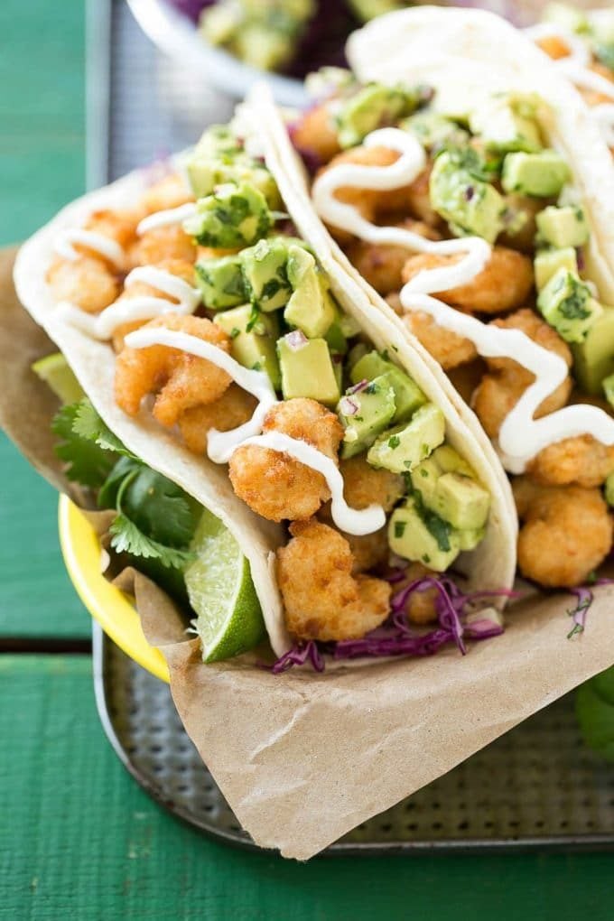 Fried shrimp tacos in flour tortillas with avocado relish and sour cream.