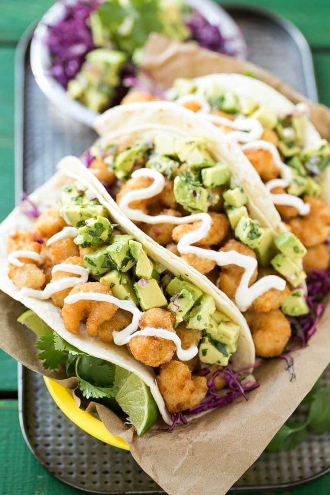 A basket of crispy shrimp tacos with avocado salsa.