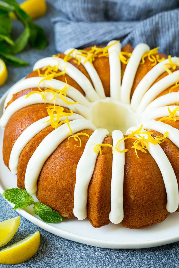 A lemon bundt cake topped with cream cheese frosting and lemon zest.