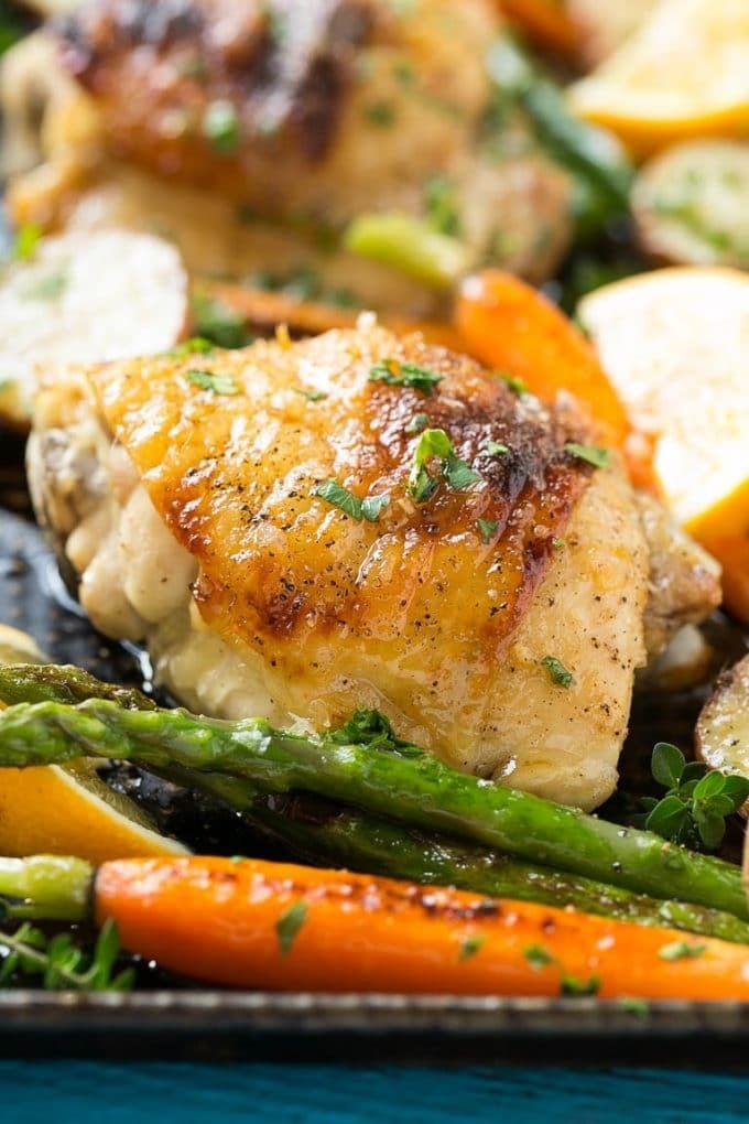 Lemon thyme chicken on a sheet pan with asparagus and carrots.