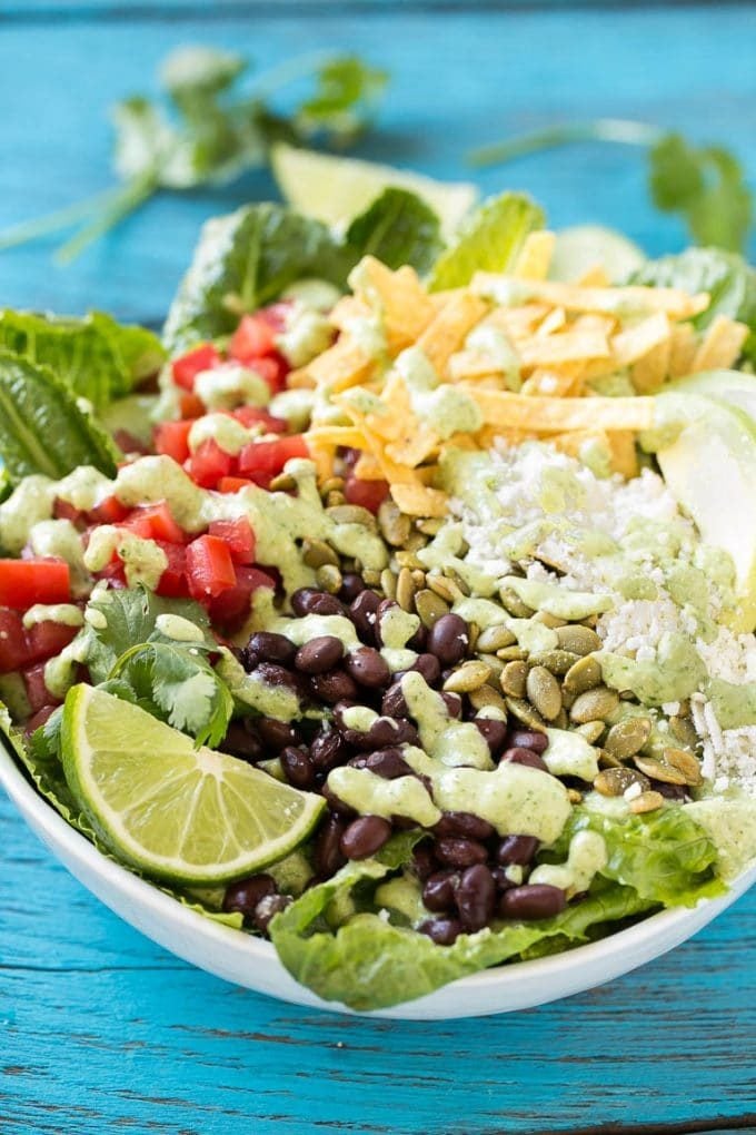 Creamy cilantro dressing drizzled over a bowl of Mexican Caesar salad.