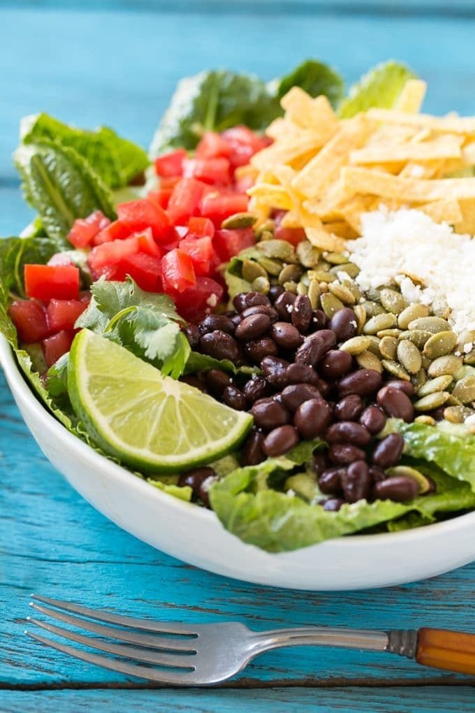 Mexican Caesar salad with black beans, tomatoes, cotija cheese and tortilla strips.