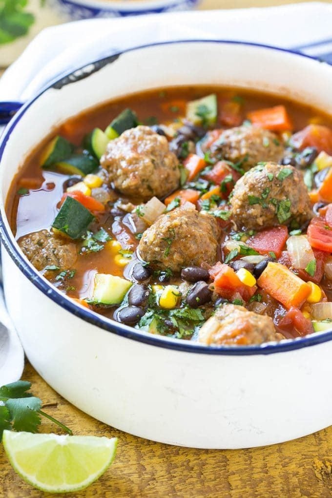 A pot of Mexican meatball soup with vegetables and black beans.