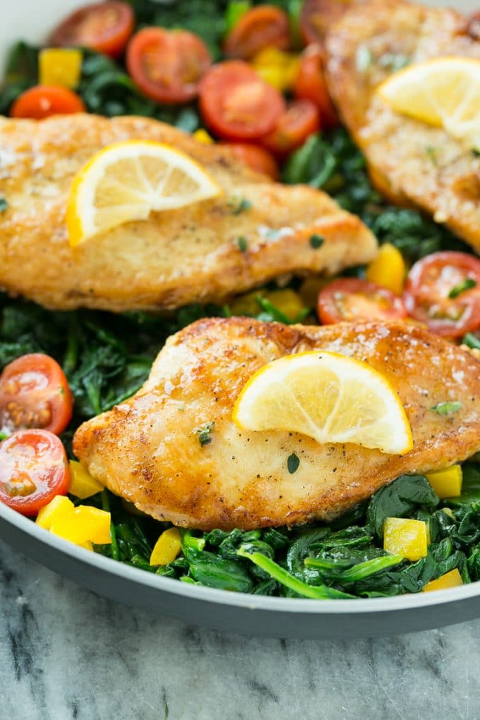 Seared chicken breasts with lemon, tomatoes and bell pepper.