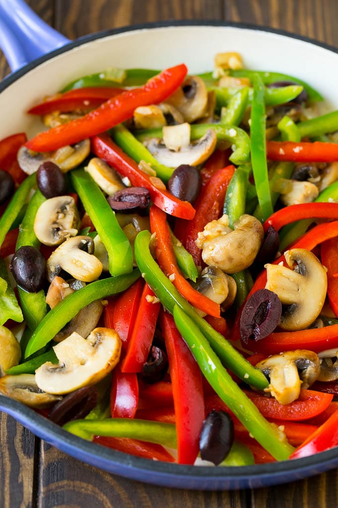 Peppers, mushrooms and olives in a pan.