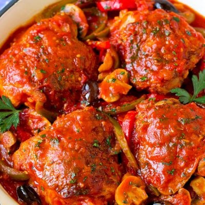 Chicken cacciatore with chicken thighs, peppers, olives and mushrooms in tomato sauce.