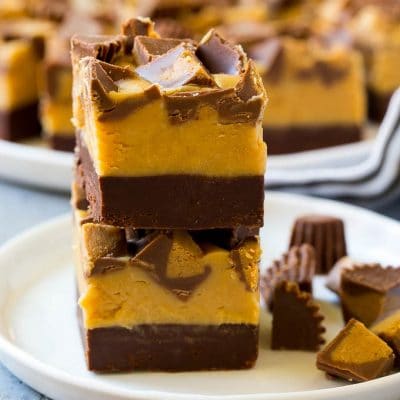 Stacked pieces of chocolate peanut butter fudge on a plate.